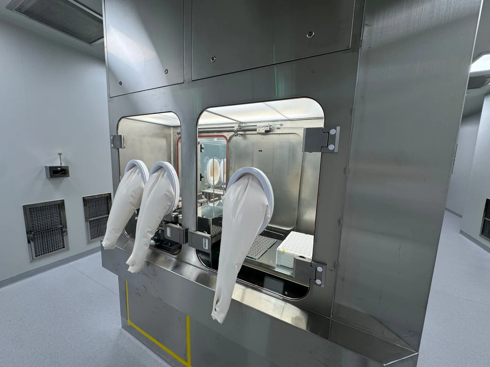 Isolator workstation with glove ports and patch trays inside, in the aseptic CLOPAM plant